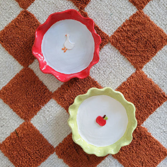 Handmade Ceramic Dish with scalloped edge. Red with a picture of a duck and yellow with a picture of a red apple